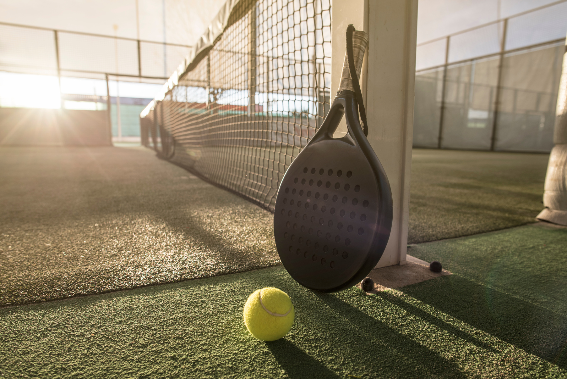 Paddle tennis racket and ball in sunset image